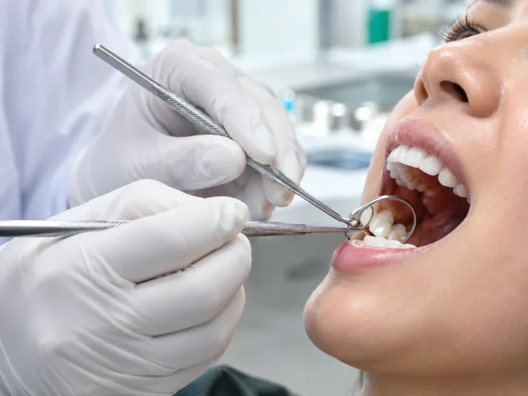 A dentist examines a patient's teeth with dental instruments.